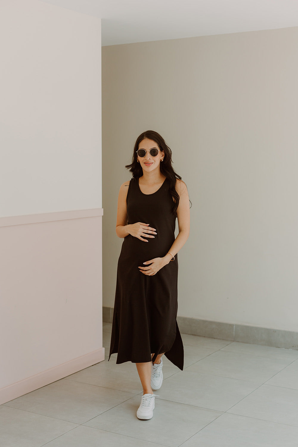 Mujer emabrazada usando un vestido negro.