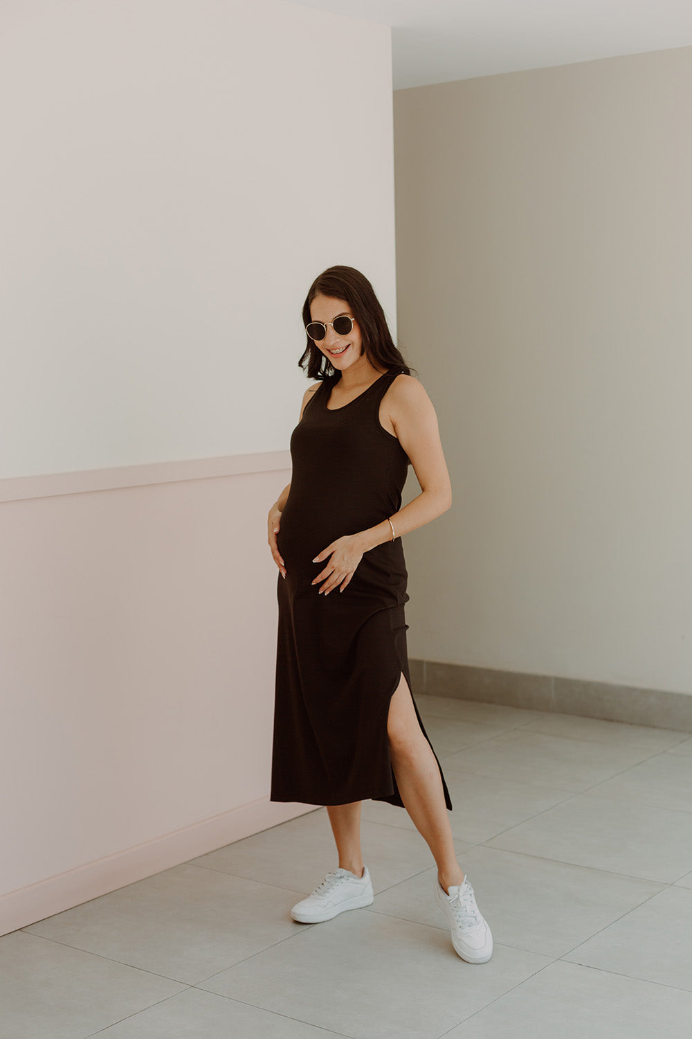 Mujer emabrazada usando un vestido negro.