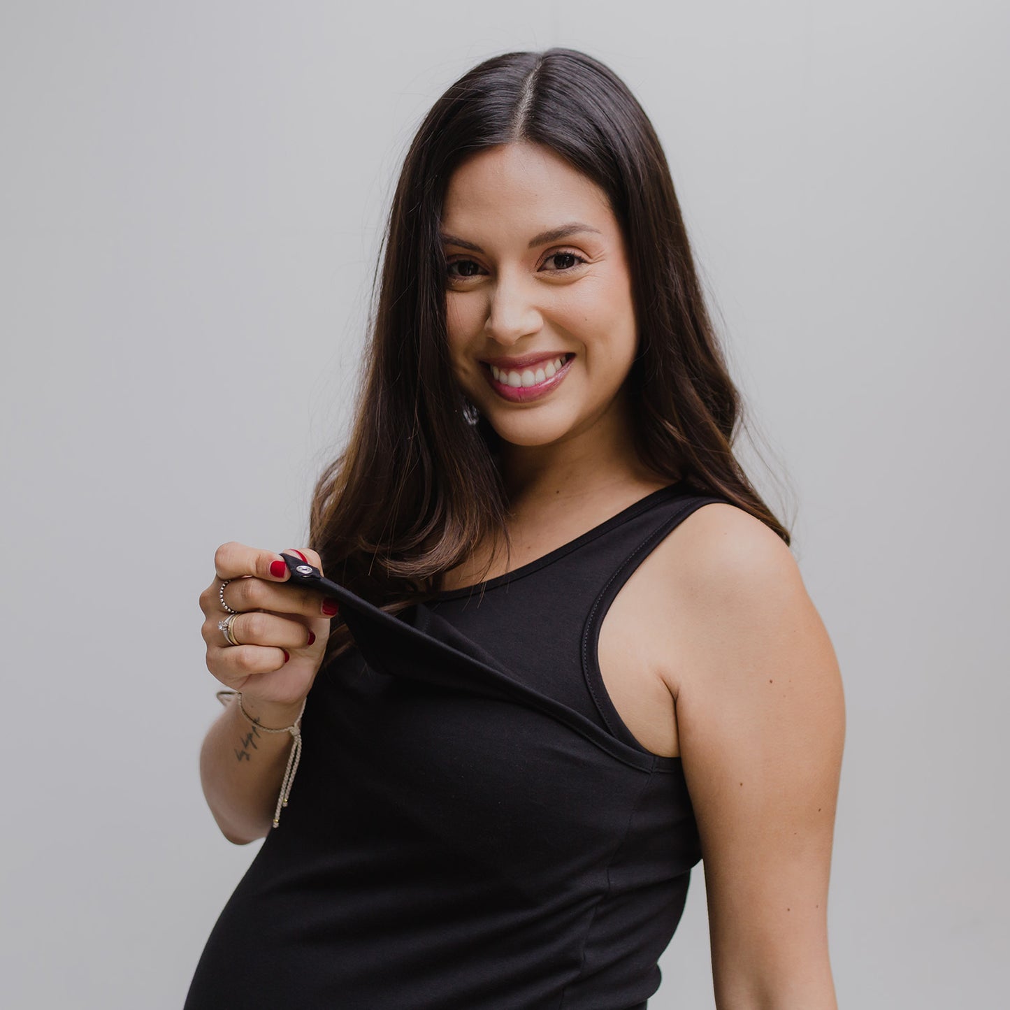 Mujer emabrazada usando un vestido negro.