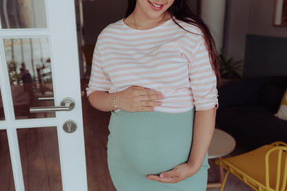 Mujer embarazada usando una falda color verde jade.