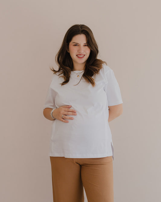Mujer embarazada usando un polo básico color blanco.