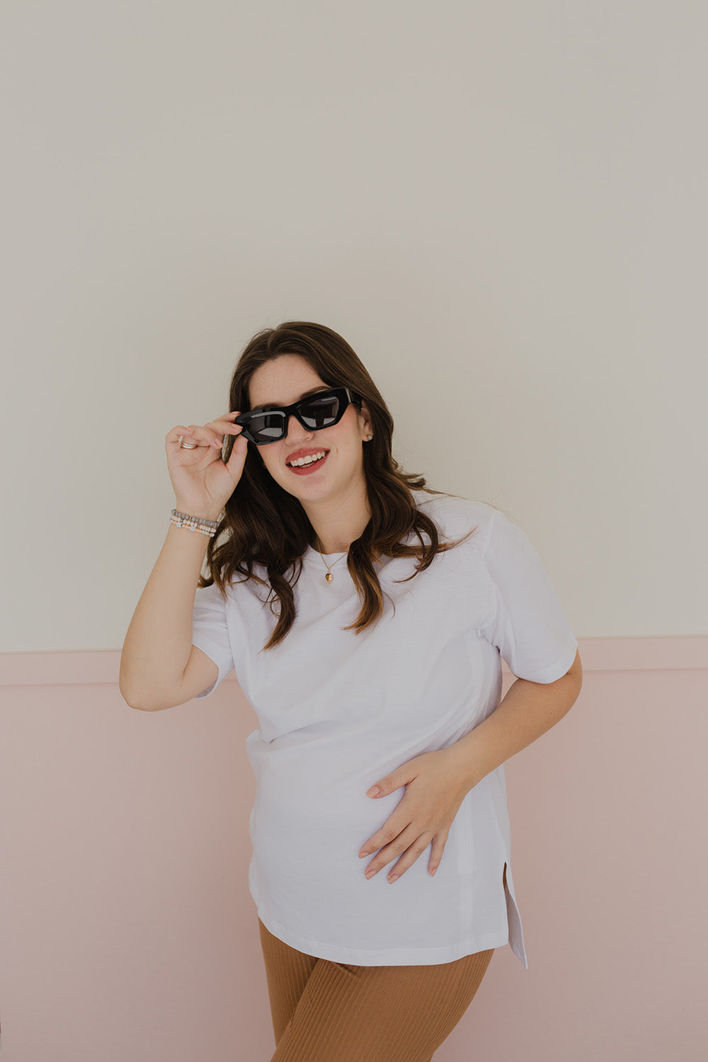 Mujer embarazada usando un polo básico color blanco.