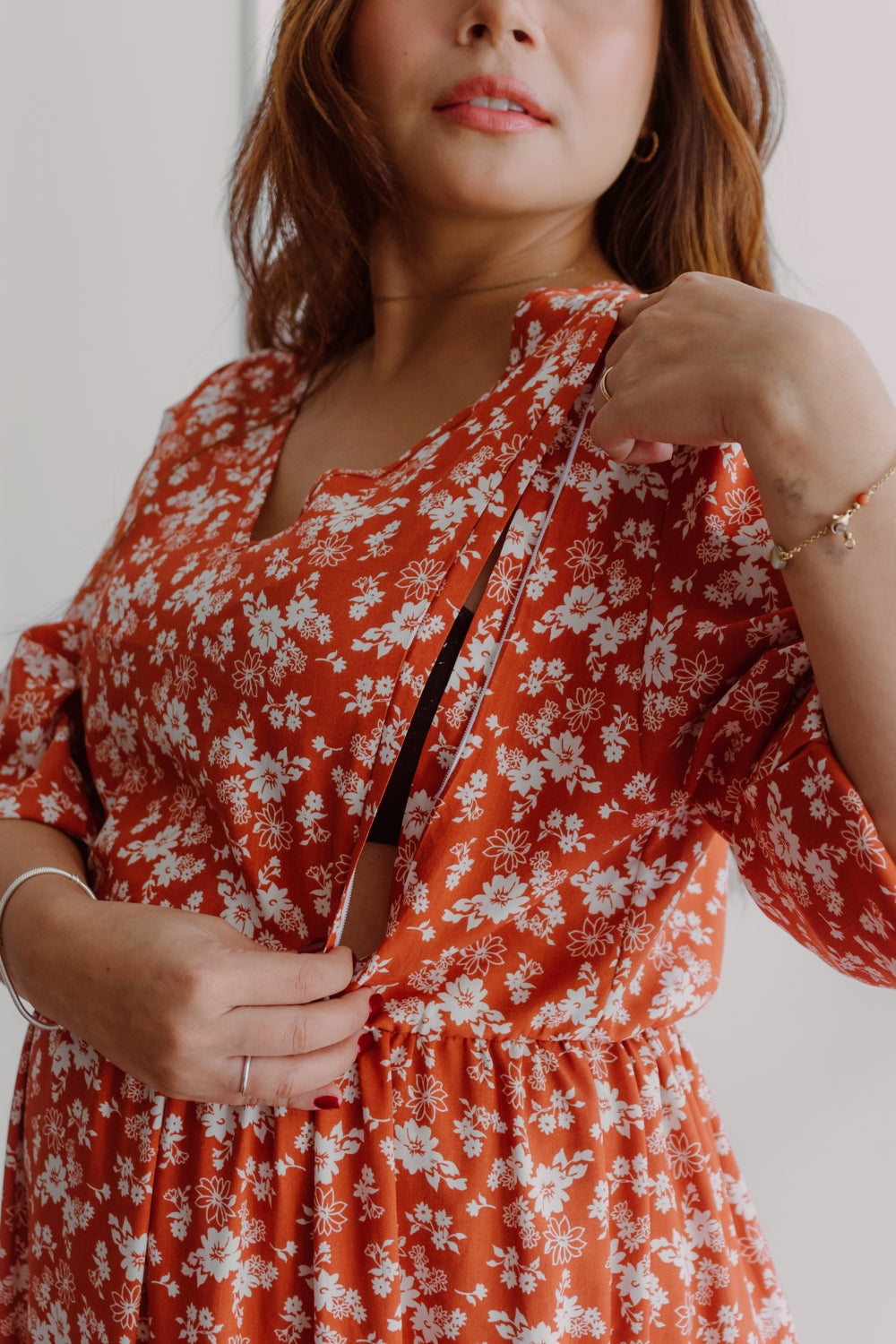 Mujer embarazada usando un vestido de manga larga estampado en color lacre.